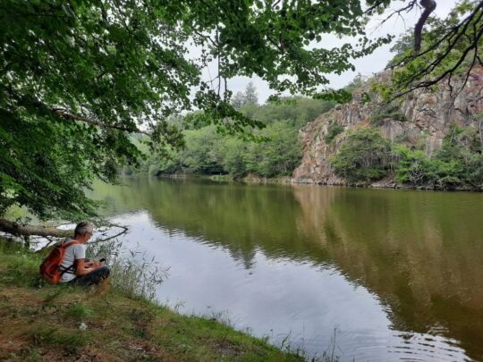 persoon met rugzak zittend aan rivier in Frankrijk