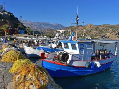 Griekenland relaxte single wandelreis op Kreta kleurige vissersboten in baai in Griekenland