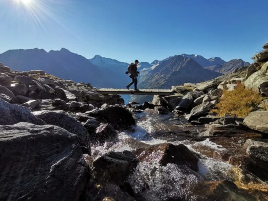 man op smalle brug in de bergen van Oostenrijk