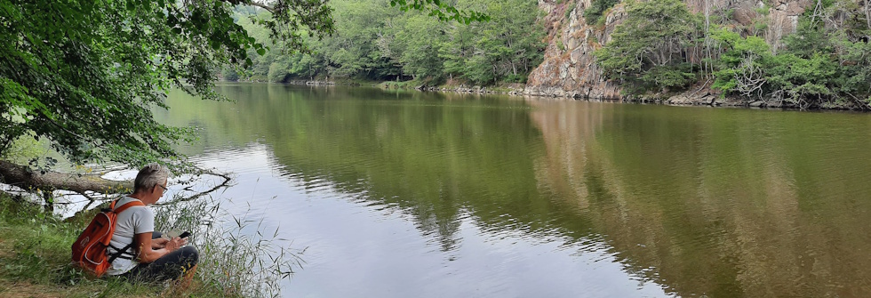 Frankrijk individuele trektocht Vrouw met rugzak zittend aan een rivier