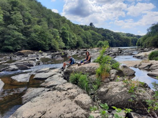 2 personen zittend op rotsblokken in rivier in Frankrijk