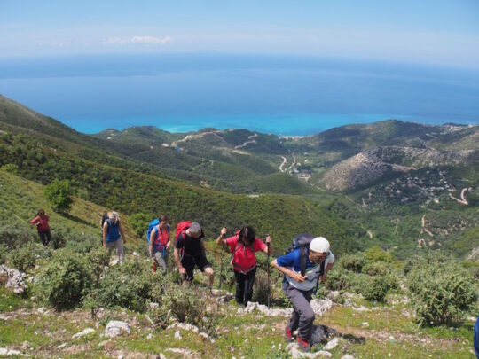 wandelaars in de bergen met zee op achtergrond